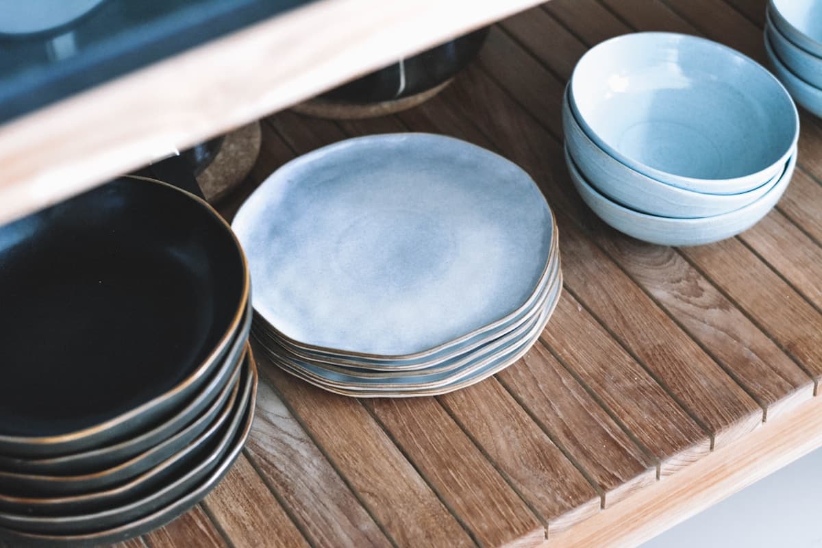 Hand-glazed blue ceramic bowls on a wooden shelf